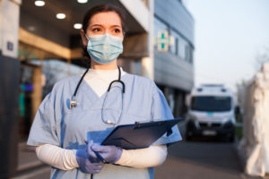 Young,Female,Ems,Key,Worker,Doctor,In,Front,Of,Healthcare